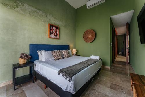 a bedroom with a bed in a room with green walls at Casa Mara 53 Luxury House in downtown Mérida in Mérida