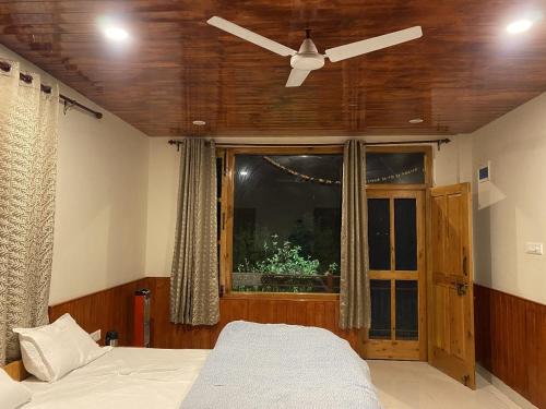 a bedroom with a ceiling fan and a window at North Katmor homestay in Haripūr
