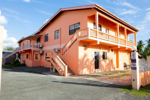 a large orange building with a staircase in front of it at Lesville Tobago in Canaan