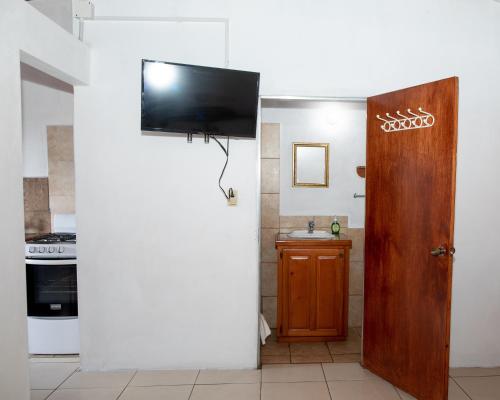 a living room with a television on a wall at Lesville Tobago in Canaan