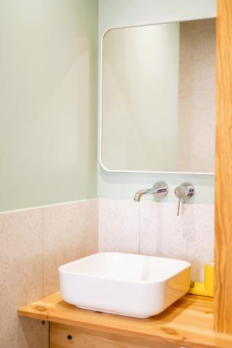 une salle de bain avec un lavabo blanc et un miroir dans l'établissement Villa Cocoon Contis océan à 900m, à Lit-et-Mixe