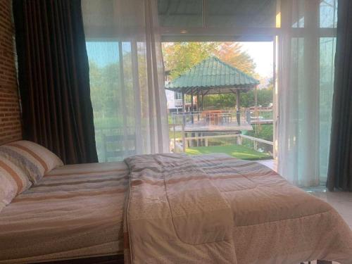 1 dormitorio con 1 cama frente a una ventana grande en Sleepy Lagoon, en Mu Si