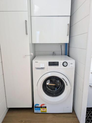 a white washer and dryer in a small room at Guest House in Sydney