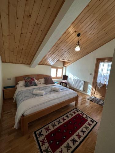 a bedroom with a large bed in a room with wooden ceilings at konaku in Tomin