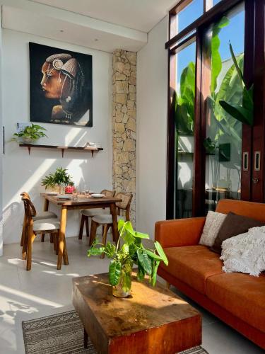 een woonkamer met een bank en een tafel bij The Green Atelier Bali in Jimbaran