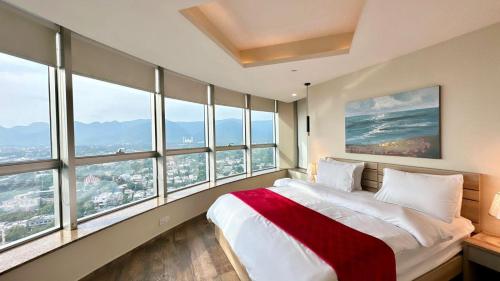 a bedroom with large windows and a bed with a red blanket at Luxury Centaurus Apartments Islamabad in Islamabad