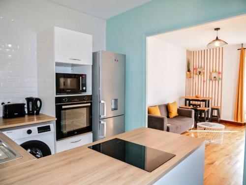 une cuisine et un salon avec un réfrigérateur en acier inoxydable dans l'établissement Nicolas en Vienne - Cosy, Confortable, Tout équipé, à Blois