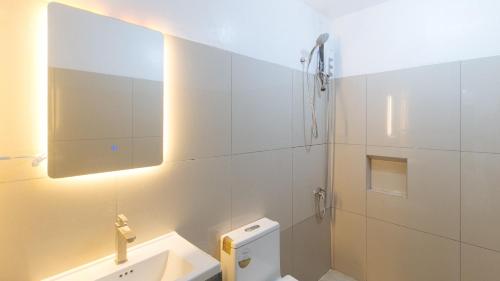 a bathroom with a toilet and a sink and a mirror at Stay Manila Hotel by RedDoorz in Manila