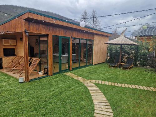 a small house with a garden and a patio at Noor House 2 in Şuncuiuş