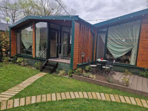 a house with a patio and a table in the yard at Noor House 2 in Şuncuiuş