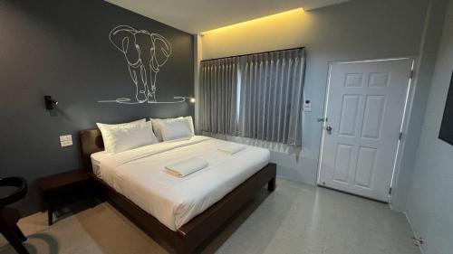 a bedroom with a large bed with white sheets at โรงแรม เกรซ รีสอร์ท สุรินทร์ in Surin