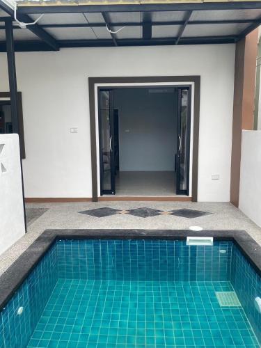 a swimming pool in the middle of a house at โรงแรม เกรซ รีสอร์ท สุรินทร์ in Surin