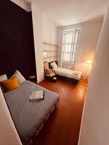 une chambre avec deux lits et une chaise et une fenêtre dans l'établissement big&cozy Flat 180m2, à Marseille