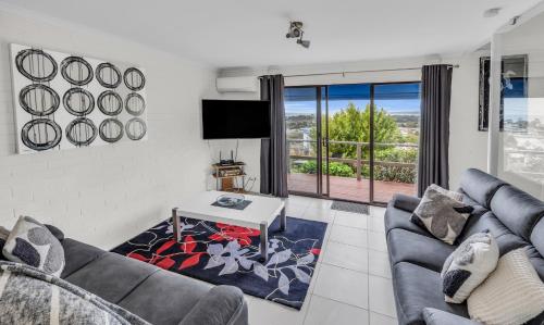 a living room with a couch and a table at Hydra Holiday Units, Merimbula in Merimbula
