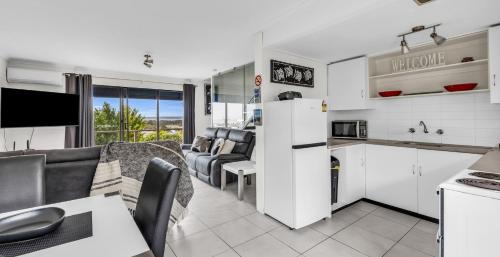 a kitchen and living room with a couch and a table at Hydra Holiday Units, Merimbula in Merimbula