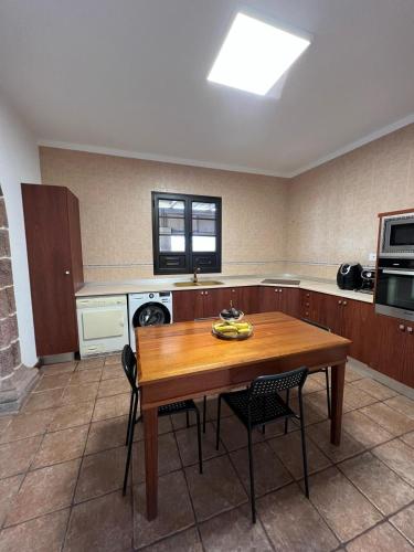 a large kitchen with a wooden table and chairs at Casona IROKO in La Costa