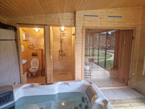 a bathroom with a tub and a toilet at Noor House 1 in Şuncuiuş