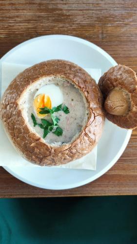 a plate of food with an egg and bread on a table at Mąka i Magia - Kuchnia regionalna - Agroturystyka in Zambrów