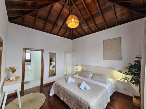 a bedroom with a large bed and a wooden ceiling at Casona IROKO in La Costa