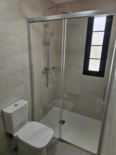 a bathroom with a toilet and a glass shower at Casona IROKO in La Costa