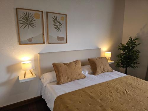 a bedroom with a bed with two lamps and a plant at Casona IROKO in La Costa