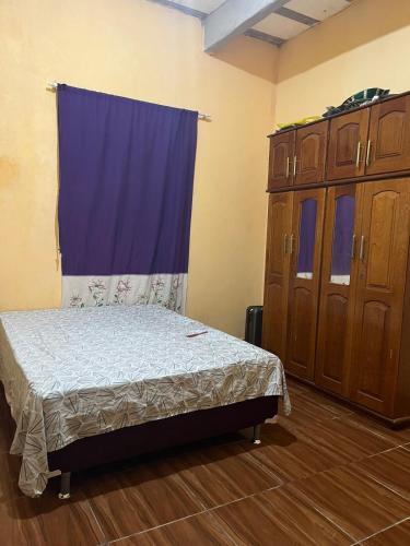 a bedroom with a bed and a blue curtain at Casa Coelho season for cop30 in Marituba
