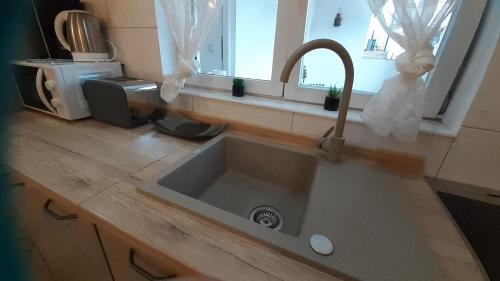 a kitchen counter with a sink and a window at apartmani G&M in Bibinje