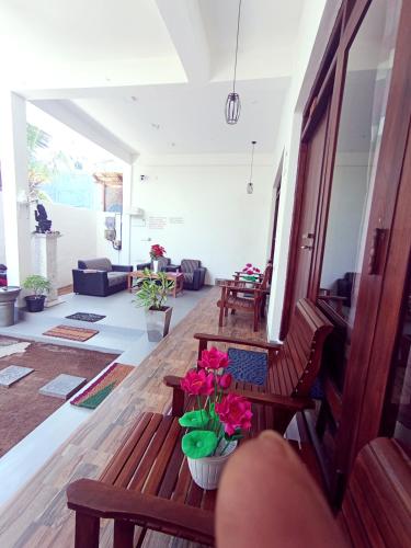 a living room with two benches and flowers on the floor at Seaware Flowers in Arugam Bay