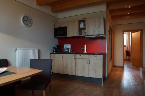a kitchen with wooden cabinets and a dining table at Pension Kramerhof in Taufkirchen