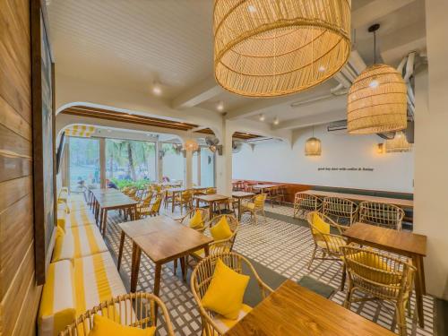 a restaurant with wooden tables and yellow chairs at Phi Phi at Pier in Phi Phi Don