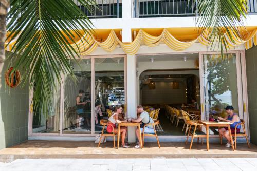 a group of people sitting at tables in front of a store at Phi Phi at Pier in Phi Phi Don