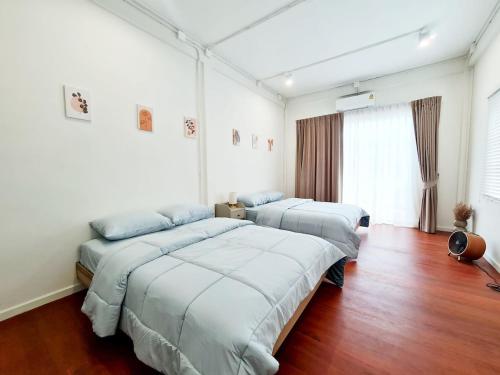 Bangkok NoiにあるWanglang Homeの白い部屋(ウッドフロア)のベッド2台