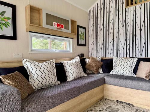a living room with a couch with pillows at The Willy Gunn Pod - Beautiful, luxury pod in Aberlour