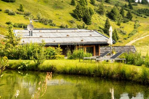 a cabin next to a lake with a hill at Chalet Stern in Vipiteno