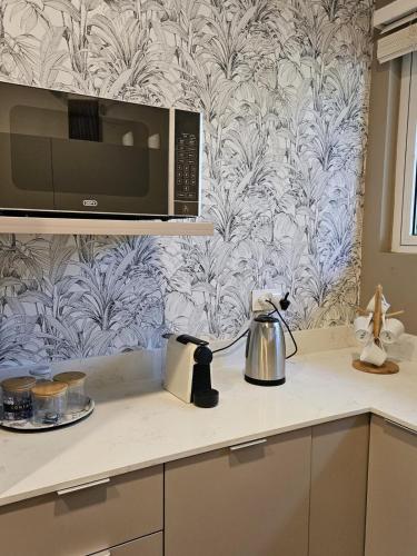 a kitchen counter with a microwave and a tea kettle at Play - Swim - Dive - Relax - Seaside Recharge in Cap Malheureux