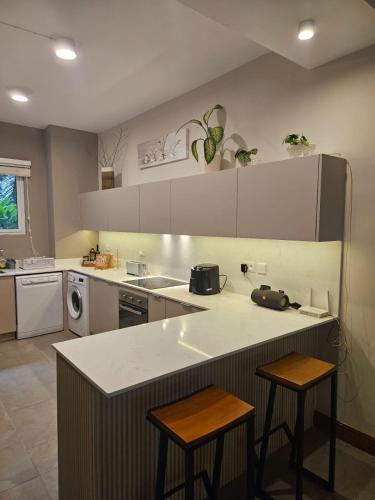 a kitchen with a counter and two stools in it at Play - Swim - Dive - Relax - Seaside Recharge in Cap Malheureux