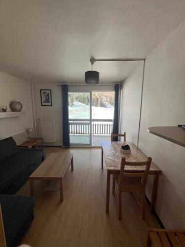 un salon avec une table et un canapé dans l'établissement Appartement Superdevoluy avec vue sur les pistes et montagne, à Saint-Étienne-en-Dévoluy