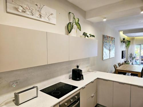 a kitchen with white cabinets and a stove top oven at Play - Swim - Dive - Relax - Seaside Recharge in Cap Malheureux