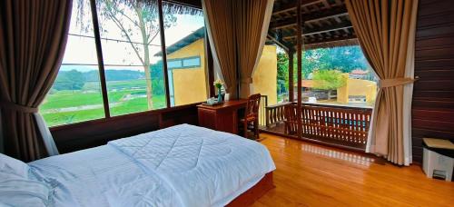 a bedroom with a bed and a large window at Moc Homestay & Villa in Cư Chinh