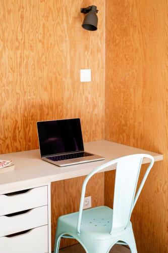 a laptop computer sitting on a desk with a chair at Villa 3 chambres Contis-plage à 900m de l océan in Lit-et-Mixe