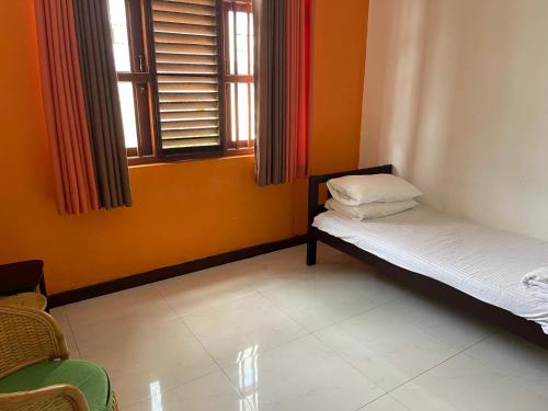 a small room with two beds and a window at Bonsai House in Nugegoda