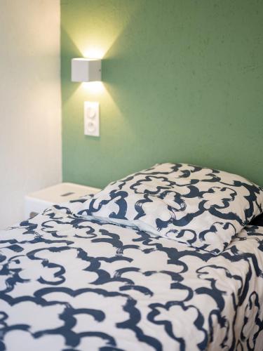 a bed with a black and white comforter on it at Villa 3 chambres Contis-plage à 900m de l océan in Lit-et-Mixe