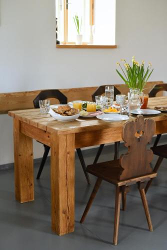 a wooden table with a plate of food on it at Roubenka U Babi in Lipná