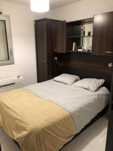 une chambre avec un grand lit avec une tête de lit en bois dans l'établissement T3 Vue Superbe sur mer et plage, à Sète