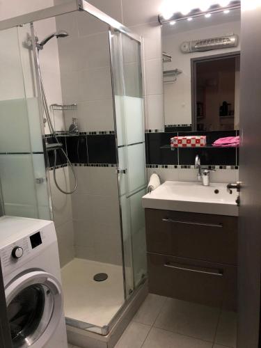 une salle de bain avec douche et lavabo et une machine à laver dans l'établissement T3 Vue Superbe sur mer et plage, à Sète