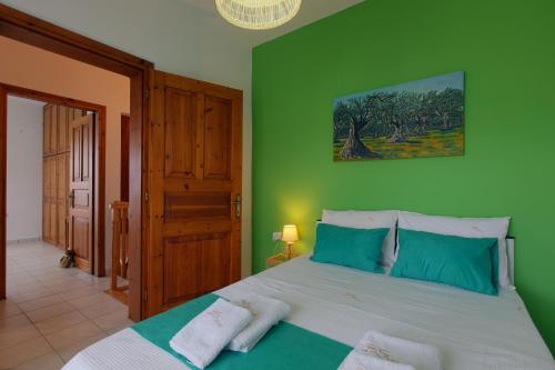 a bedroom with a large bed with green walls at BS Village green in Metamorfosi