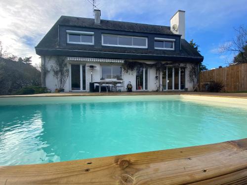 une maison avec une grande piscine en face d'une maison dans l'établissement Maison piscine Redon, à Redon