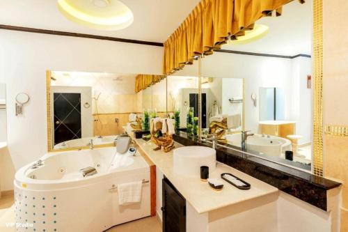 a bathroom with a tub and a large mirror at Poseidon Boutique Hotel in Pattaya South