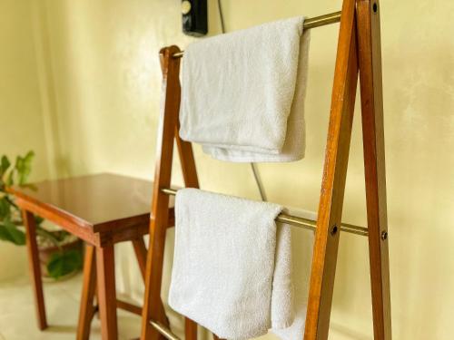 a towel rack with white towels on it next to a table at Sandybridge Eco Farm at Relly's Restaurant in Puerto Princesa City