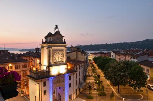 a clock tower in the middle of a city at night at Hotel Eden Salò in Salò